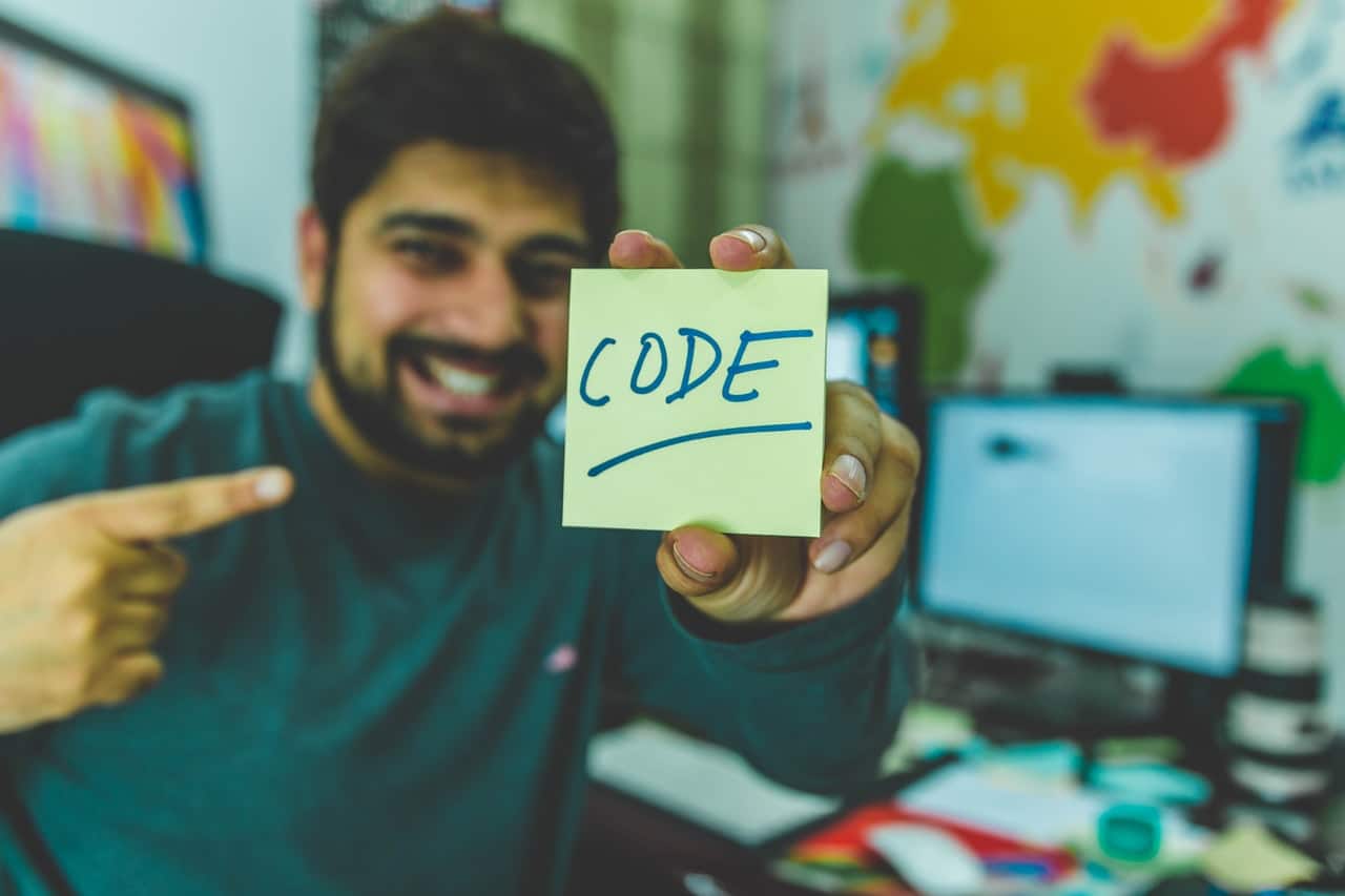 man holding a paper that says code