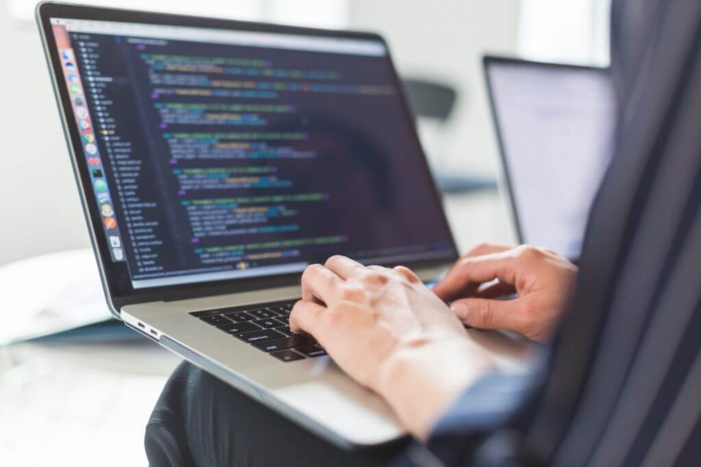 a person writing code on a laptop