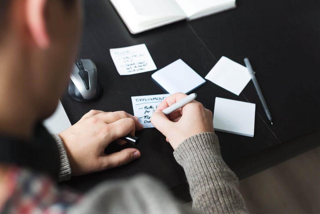 a man writing down the steps of making an app with traditional software development